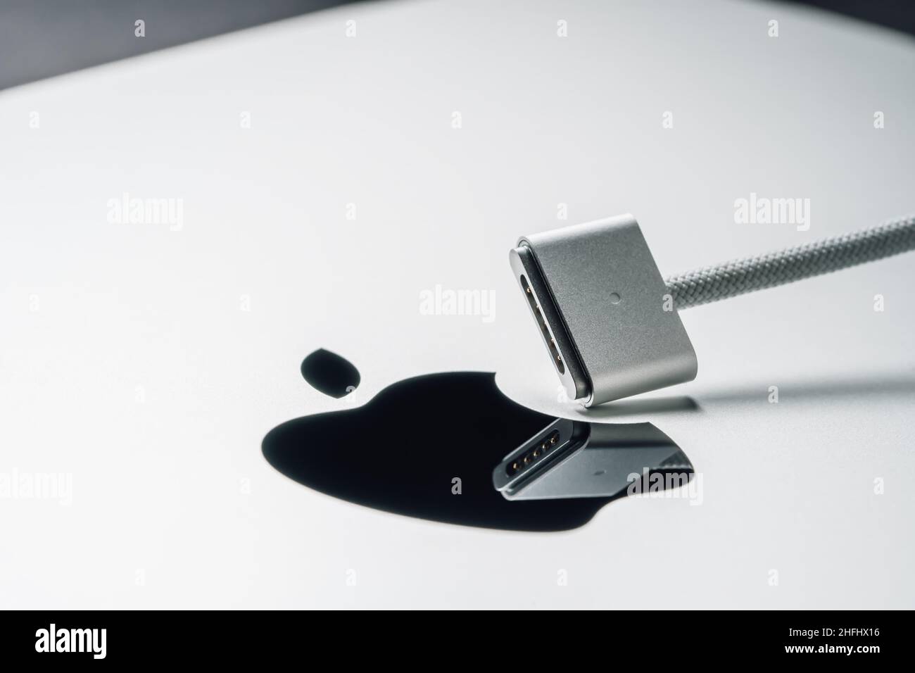 Barcelona, Spain - January 2022. MagSafe 3 power adapter for new laptop.  Macro view of charger for MacBook on Apple logo. Metal silver background  Stock Photo - Alamy