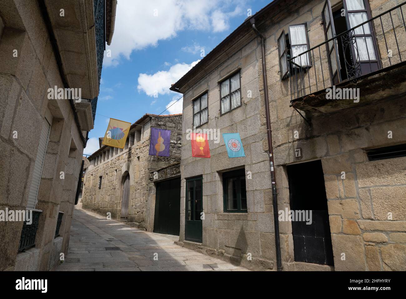 Colorful flags greet pilgrims entering the city along the Camino Portuguese in Tui, Spain. This route of the Camino de Santiago pilgrimage runs north Stock Photo