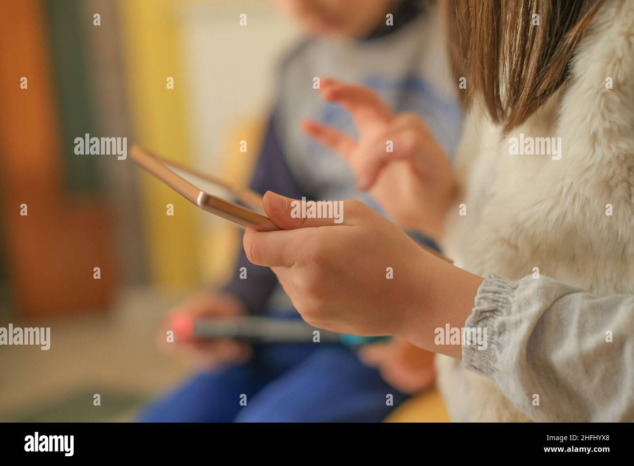 Preschooler Kids playing with portable videogames console,tech kids addiction Stock Photo