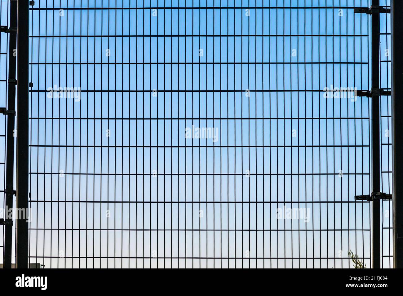 fence with grid structure with blue sky in background Stock Photo - Alamy