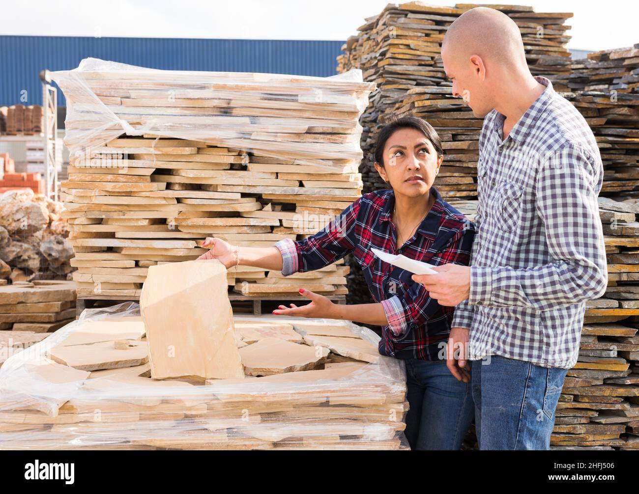 Two buyers choosing natural stone tiles at hardware store Stock Photo Alamy