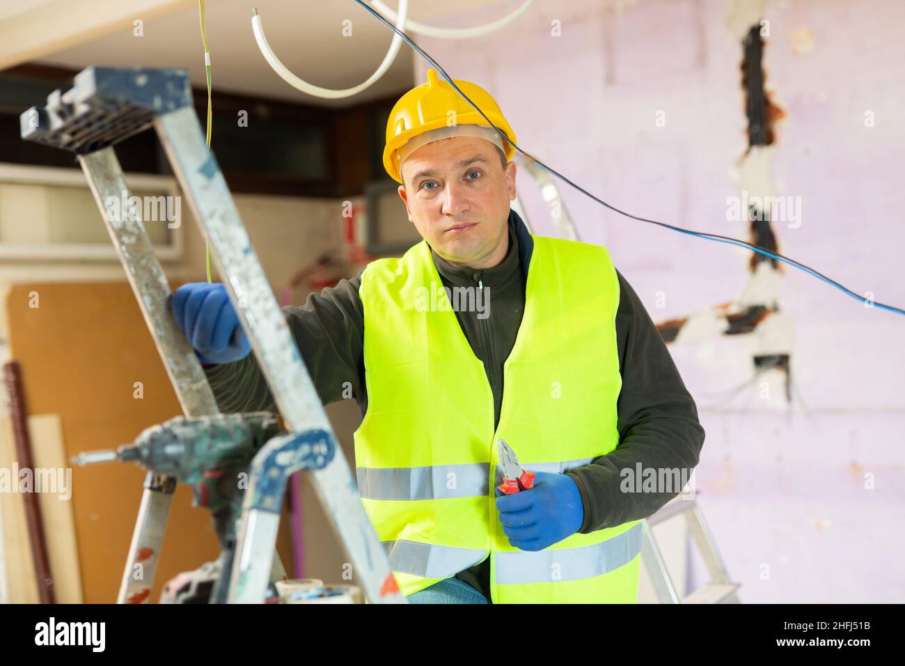 Male contractor holding electric perforator ready for construction works indoors Stock Photo