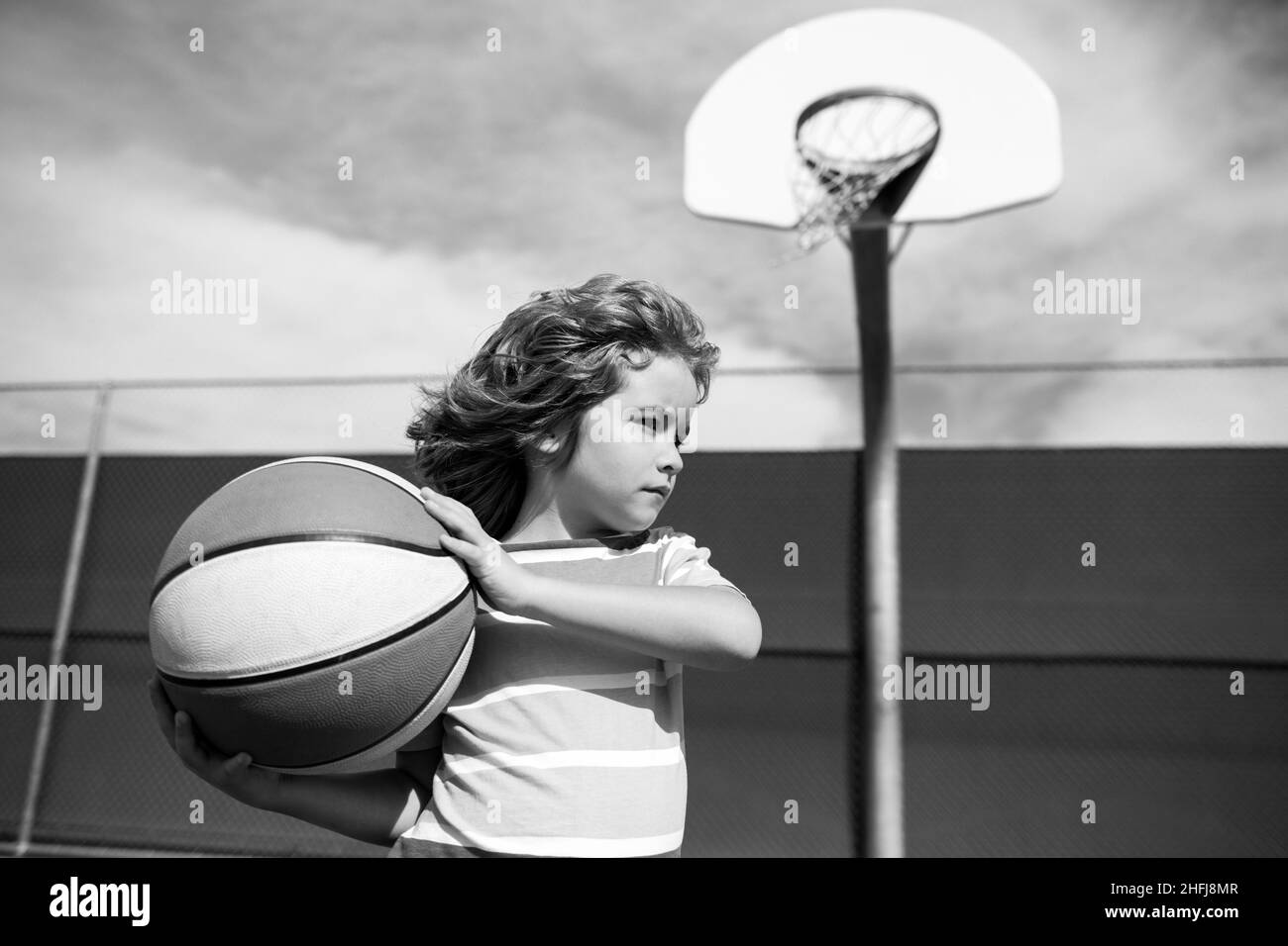 Cute child playing basketball. Basketball kids training game. Active