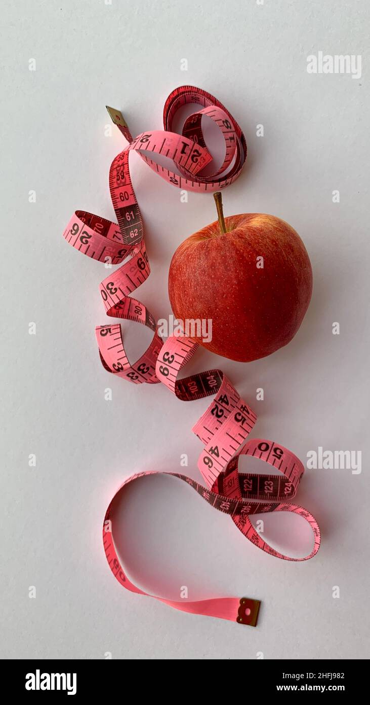 https://c8.alamy.com/comp/2HFJ982/diet-and-weight-loss-concept-organic-red-apple-weight-scale-measure-tap-and-white-background-2HFJ982.jpg