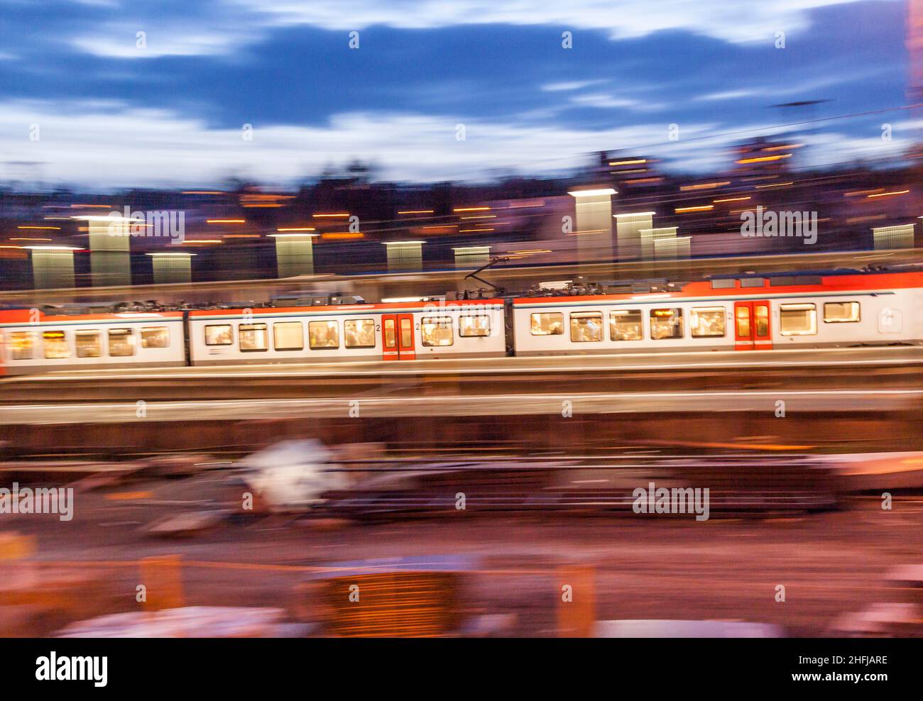 evening train traffic with rails and illuminated platform in the dark ...