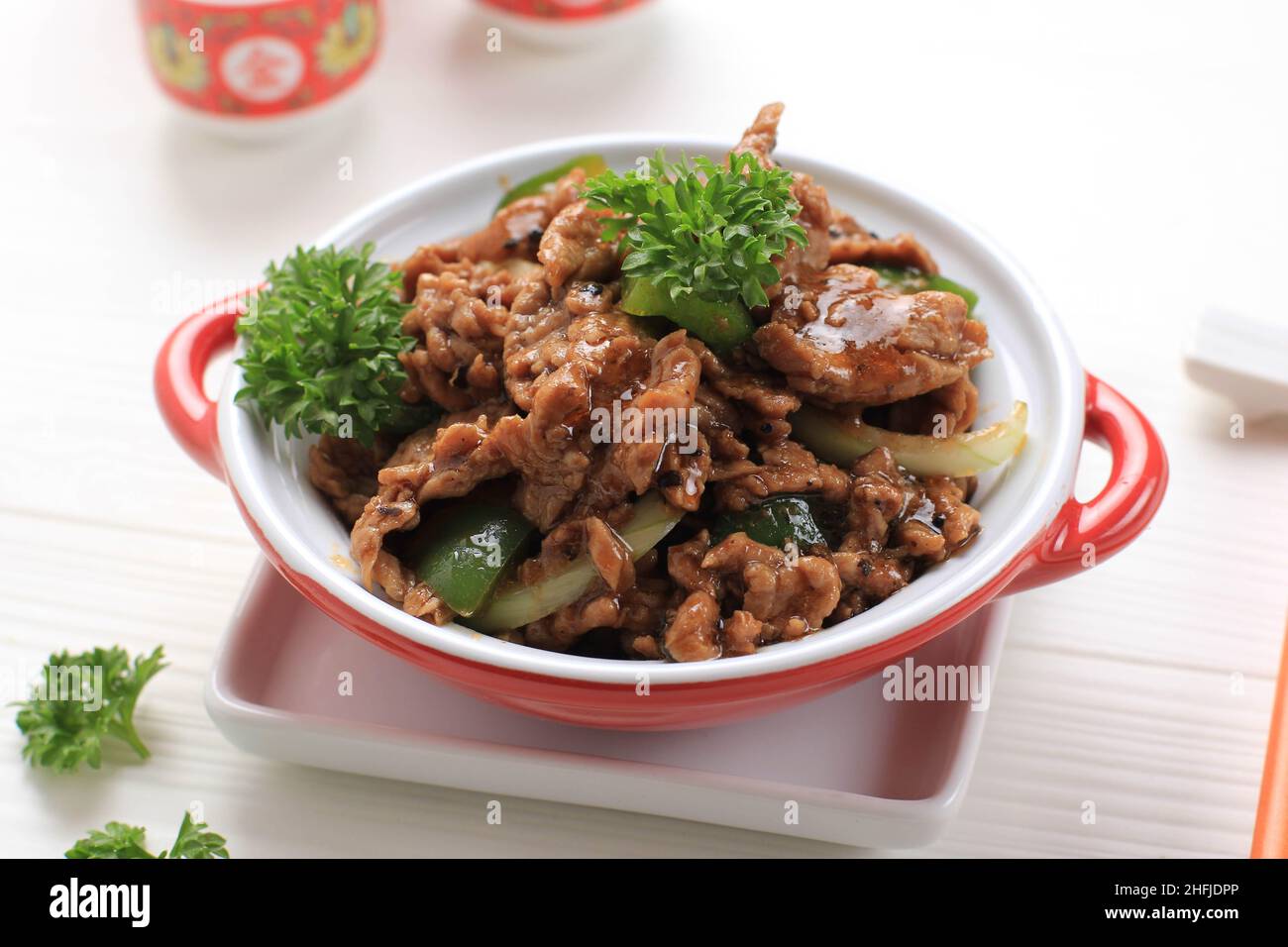 Sapi Lada hitam, Indonesian and Chinese cuisine, stir fried beef with black pepper sauce and red bell peppers, Served on Red Plate Stock Photo