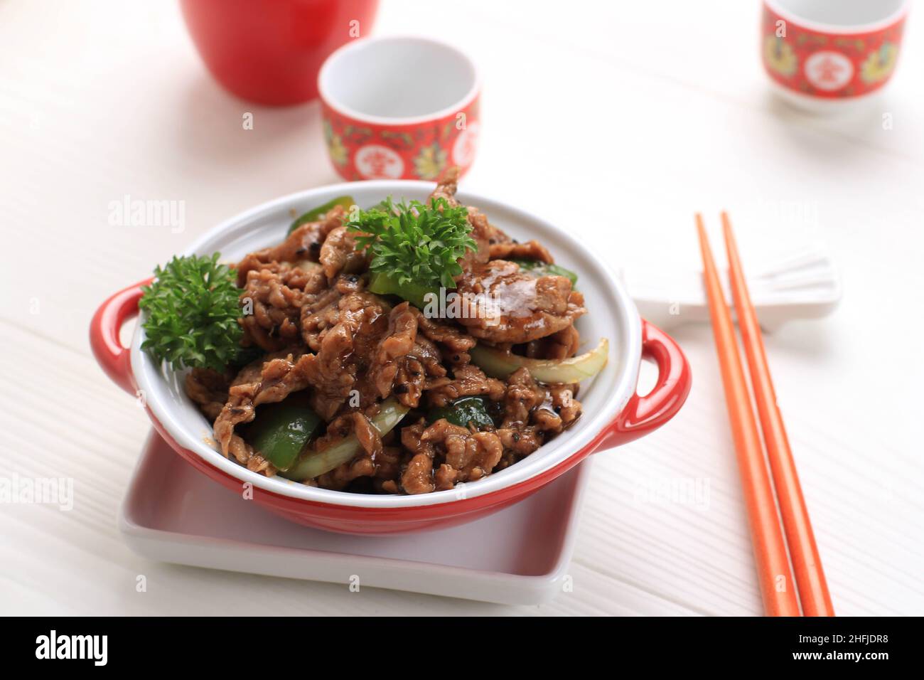 Sapi Lada hitam, Indonesian and Chinese cuisine, stir fried beef with black pepper sauce and red bell peppers, Served on Red Plate Stock Photo