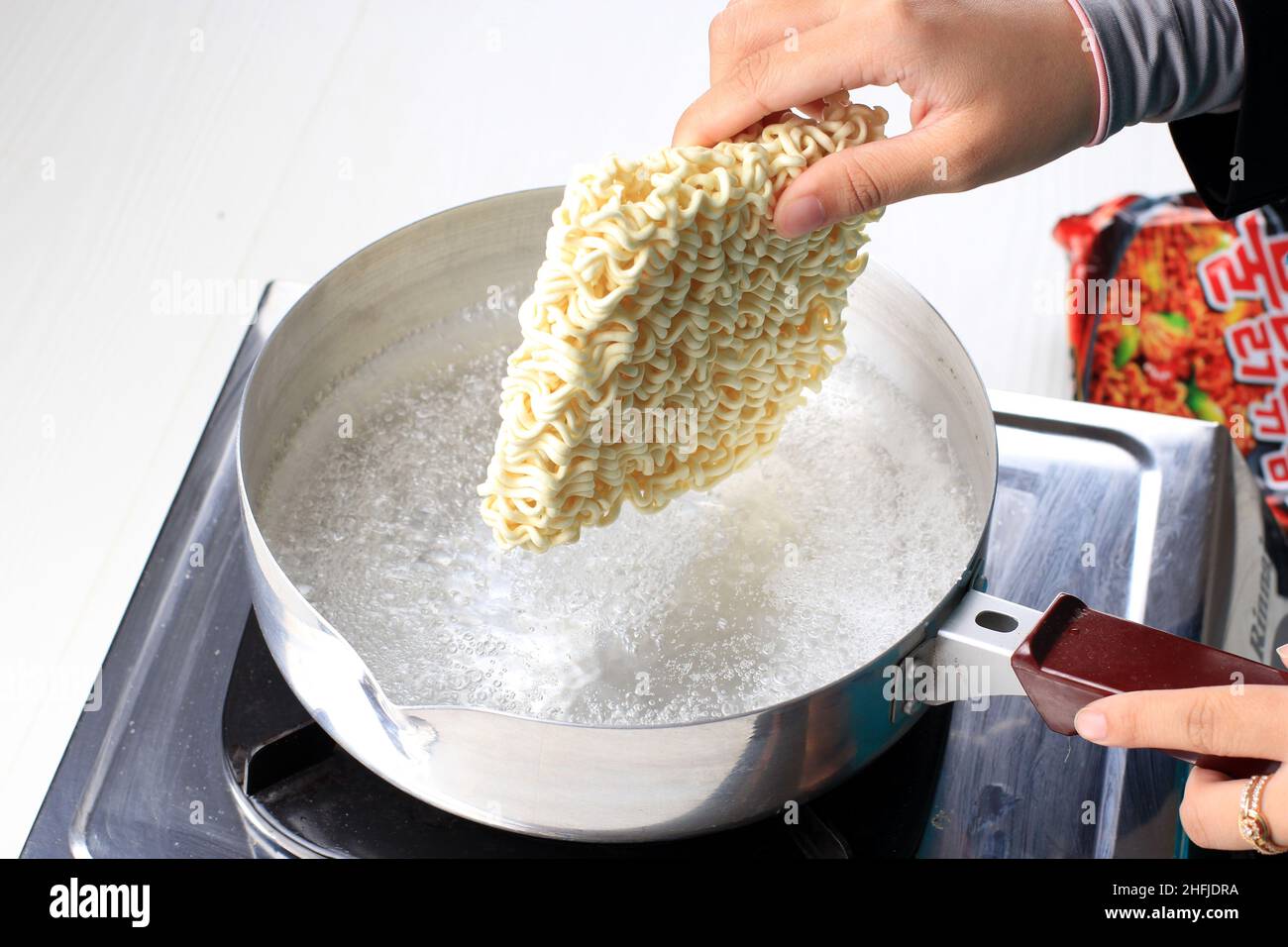 Boiling Korean Instant Noodle (Spicy Ramyun) on Sauce Pan, Add Noodle ...