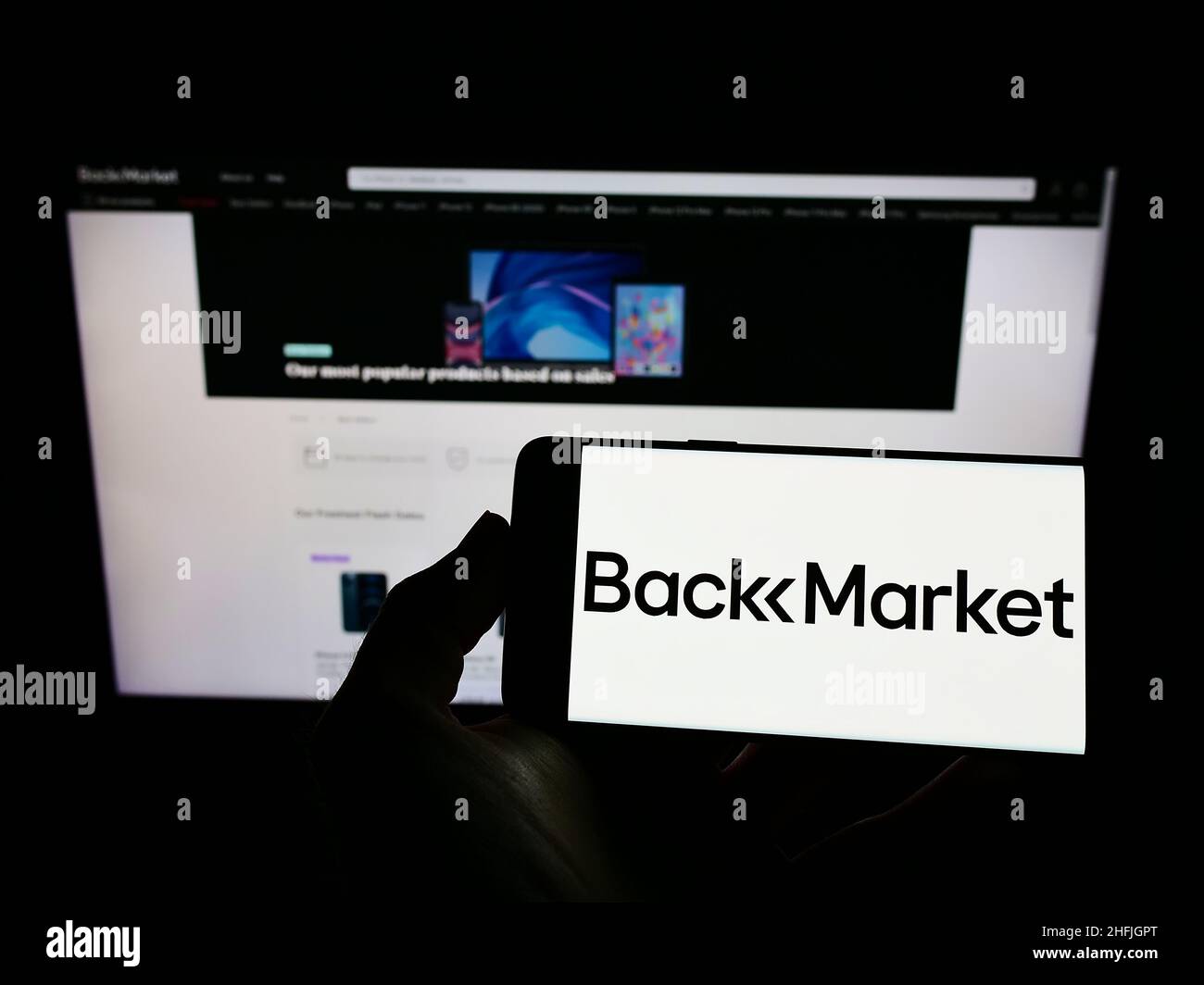 Person holding cellphone with logo of French company Back