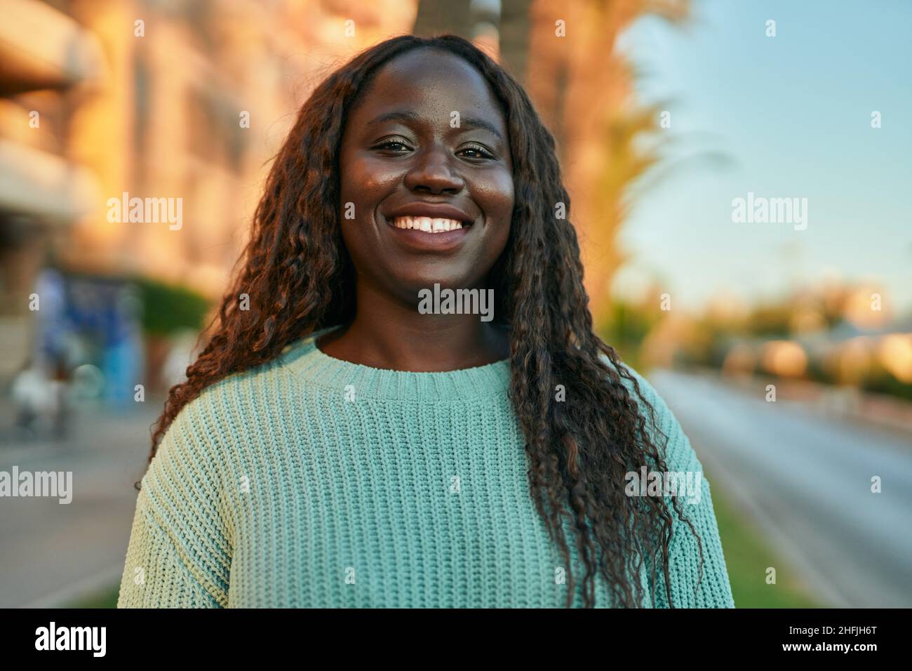 Young african woman smiling happy at the city Stock Photo - Alamy