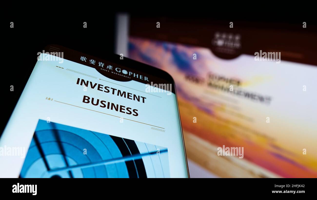 Cellphone with business website and logo of Chinese company Gopher Asset Management Ltd. on screen. Focus on top-left of phone display. Stock Photo