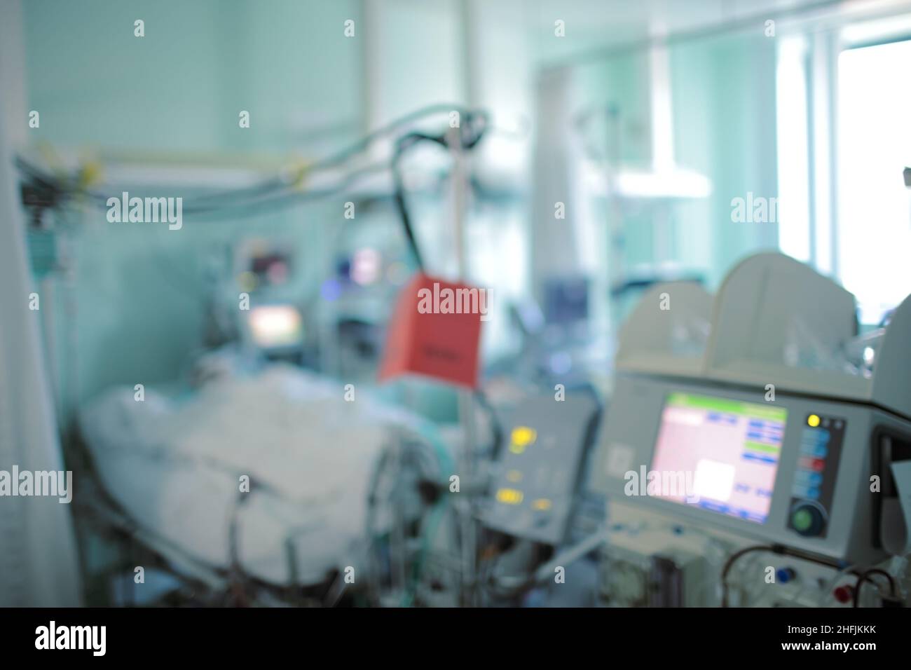 Human silhouette lying in the hospital bed and covered with white planket in the digital life support monitoring, unfocused background. Stock Photo
