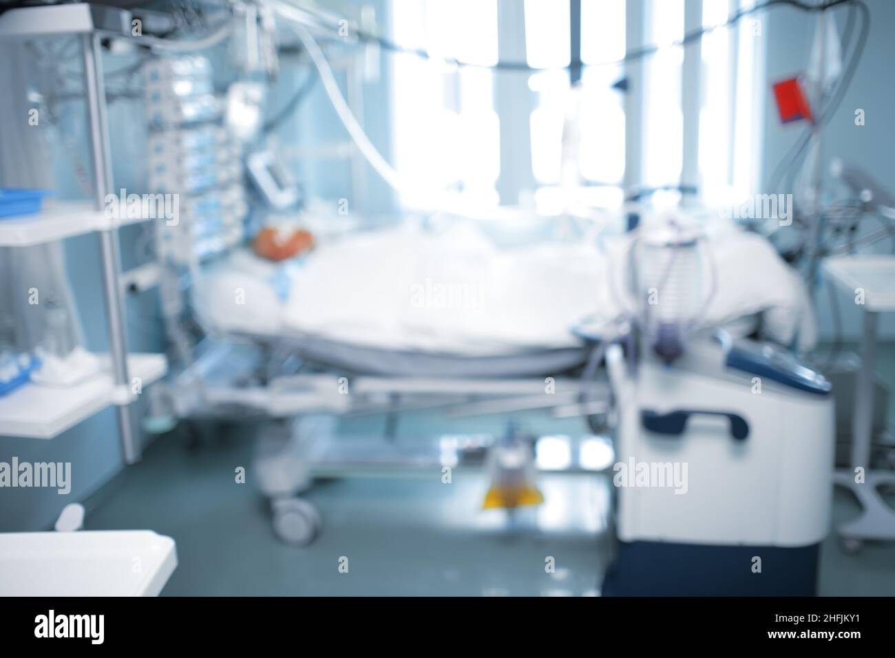 Hospital room interior with patient bed and modern digital equipment, unfocused background. Stock Photo