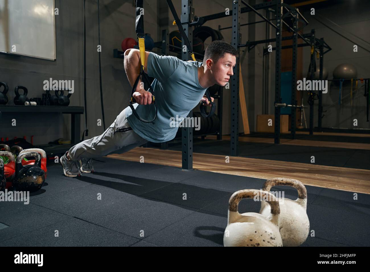 Concentrated young sportsperson performing strength training exercise ...