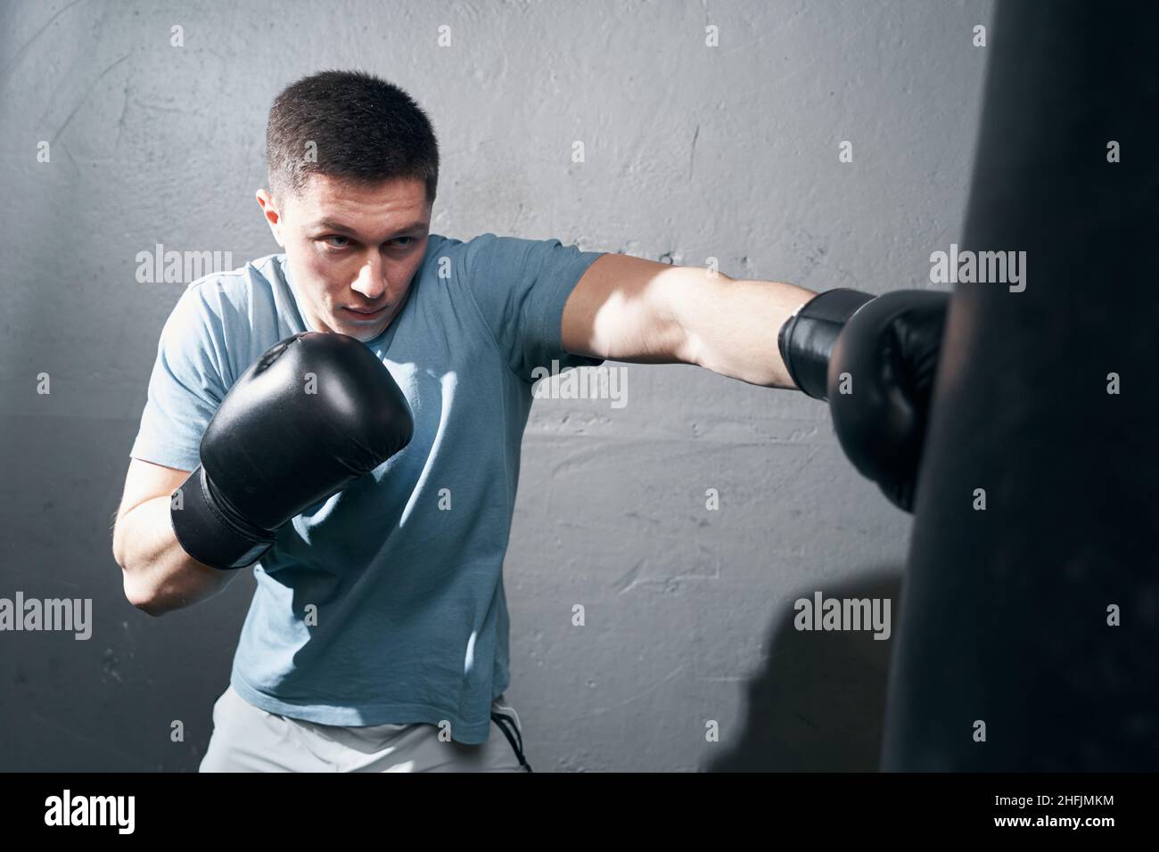 Focused young Caucasian male boxer training indoors Stock Photo