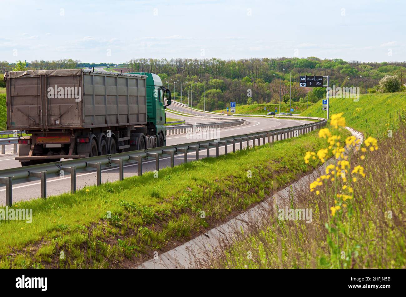 Expressway with multi-lane traffic, road bends with up and down slopes. Lorry close-up driving along the European bypass highway. Stock Photo