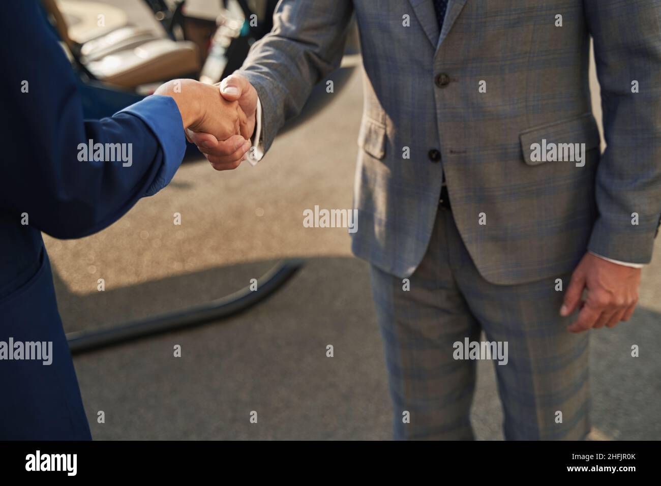 Two businesspeople standing outside and greeting each other Stock Photo ...
