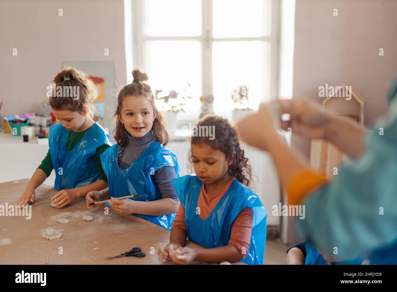 Group of little kids working with pottery clay during creative art and craft class at school. Stock Photo