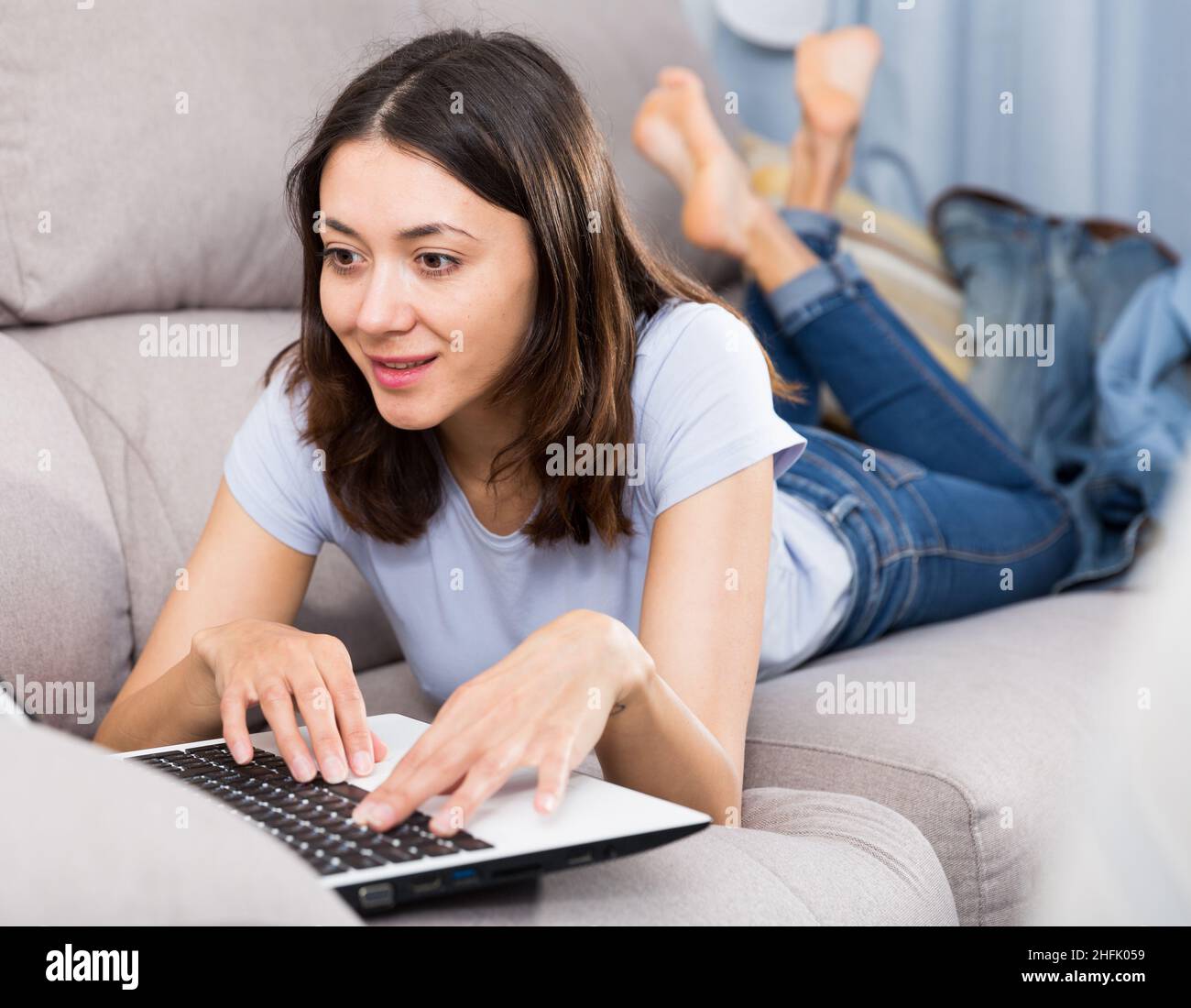 Young woman student resting with laptop on sofa at home Stock Photo - Alamy