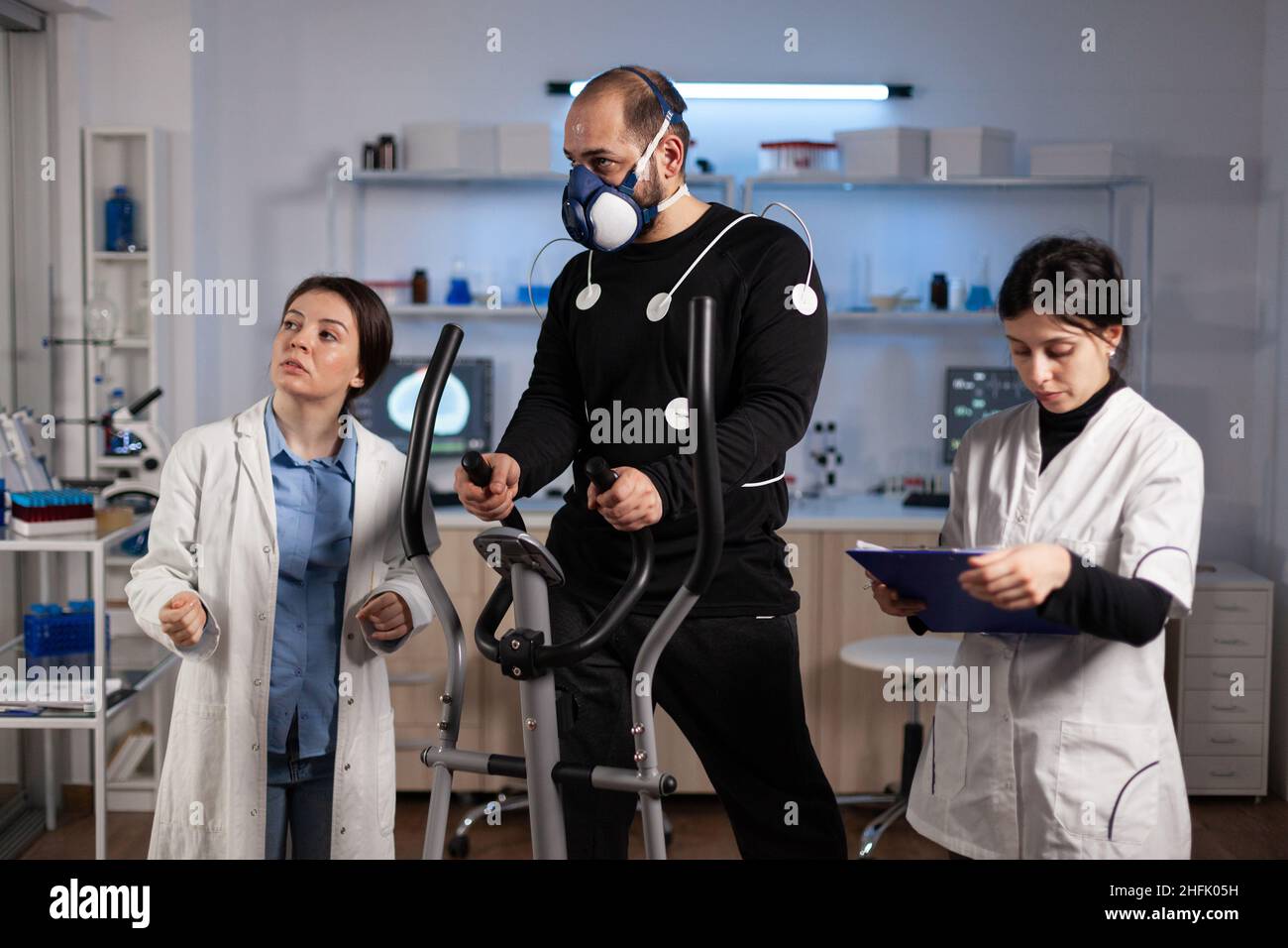Specialist team analyzing body endurance of sportman during clinical