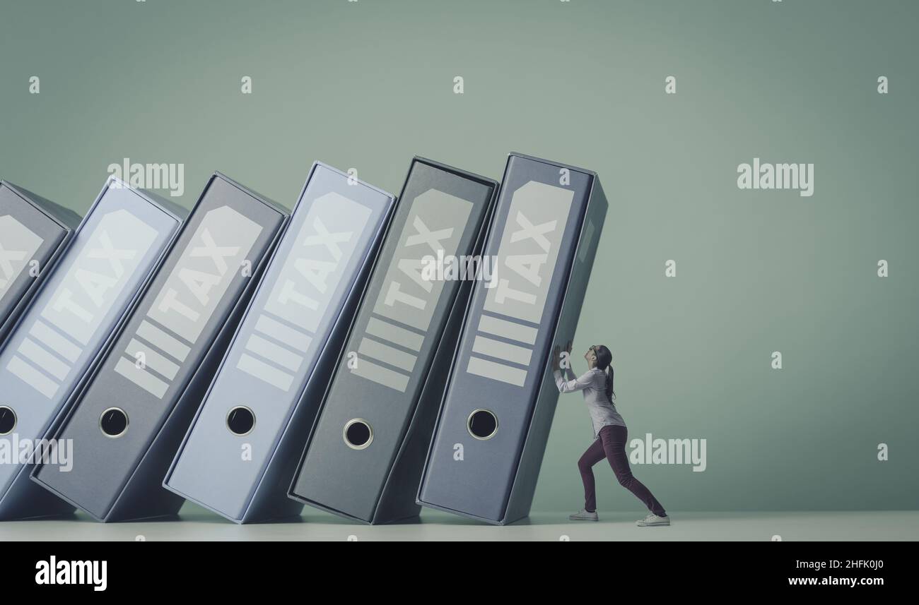 Many ring binders with tax documents and bills falling over a scared