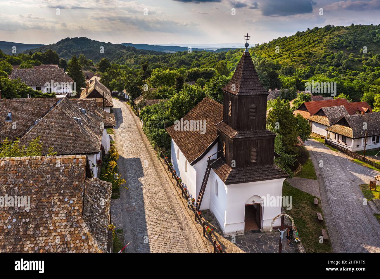 Holloko, Hungary - Aerial view of the traditional catholic church of Holloko at the village centre, an UNESCO site in Hungary on a sunny summer day Stock Photo