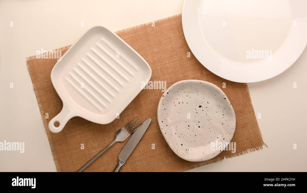 Empty white ceramic plate on a white background with a knife and fork ...