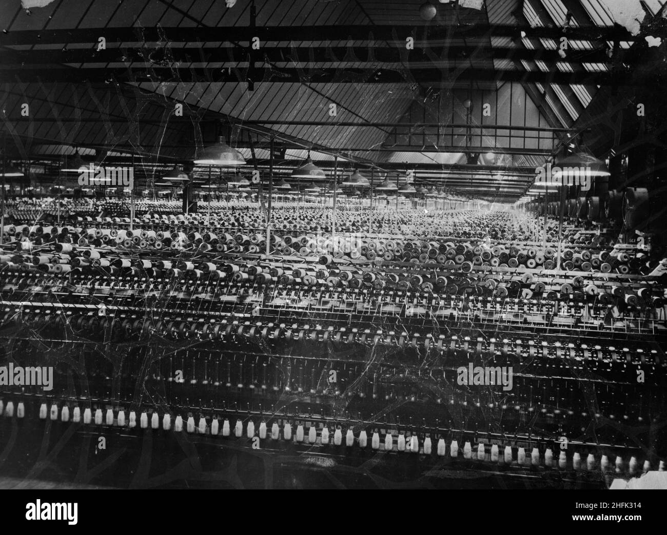 Patons and Baldwins Knitting Factory, Lingfield Close, Darlington, 1947 - 1949. Rows of spinning machinery in the spinning shed at Patons and Baldwins knitting factory. This is a copy negative that appears to have been made by Laing on 28th October 1955. The image was published in the March 1949 issue of Laing's monthly newsletter, Team Spirit. At the time of publication, two thirds of the work at the site had been completed and a small portion of the factory had already been in use for over a year. Stock Photo