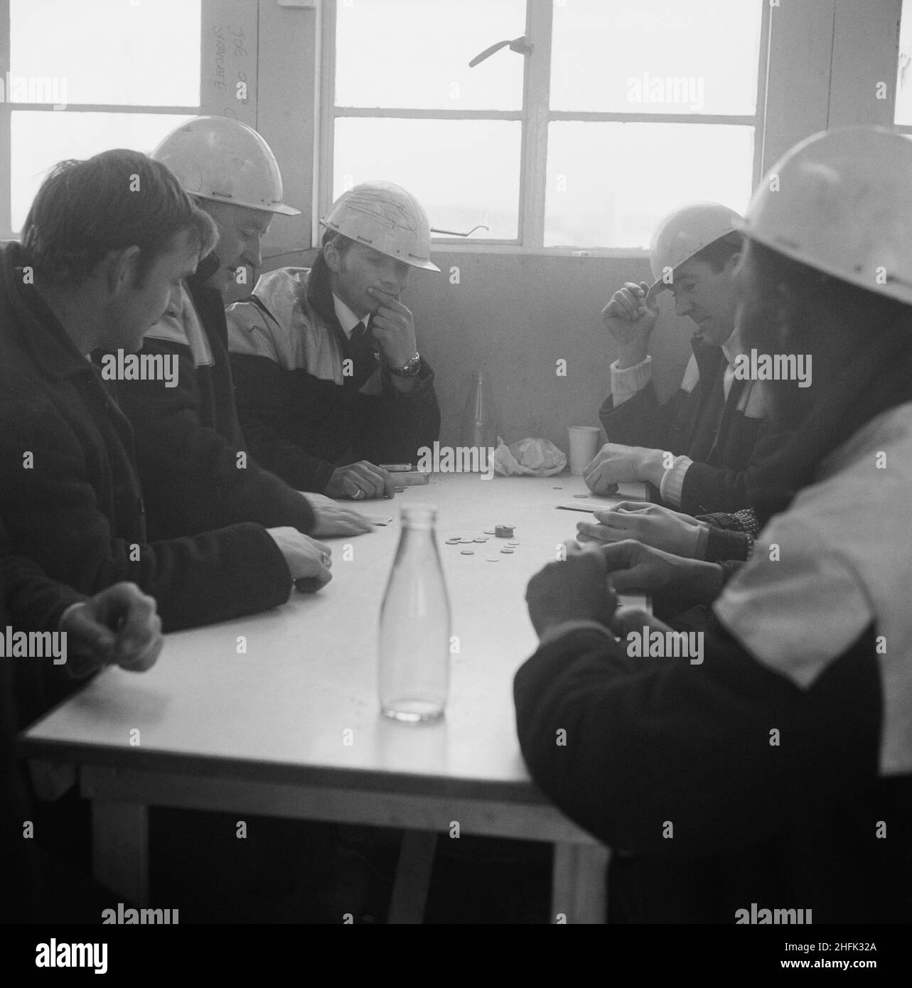 Heathrow Airport, BEA Servicing Hangar, Heathrow, Hillingdon, London, 07/04/1970. Laing workmen playing a card game at a table in the site canteen during the construction of the BEA aircraft servicing hangar at Heathrow Airport. In October 1969 Laing announced that its Industrial Engineering Branch had been awarded a contract for construction of an aircraft servicing hangar for British European Airways at Heathrow Airport. It was the company&#x2019;s second major contract at Heathrow, following the completion of the BEA and BOAC cargo terminal. Stock Photo