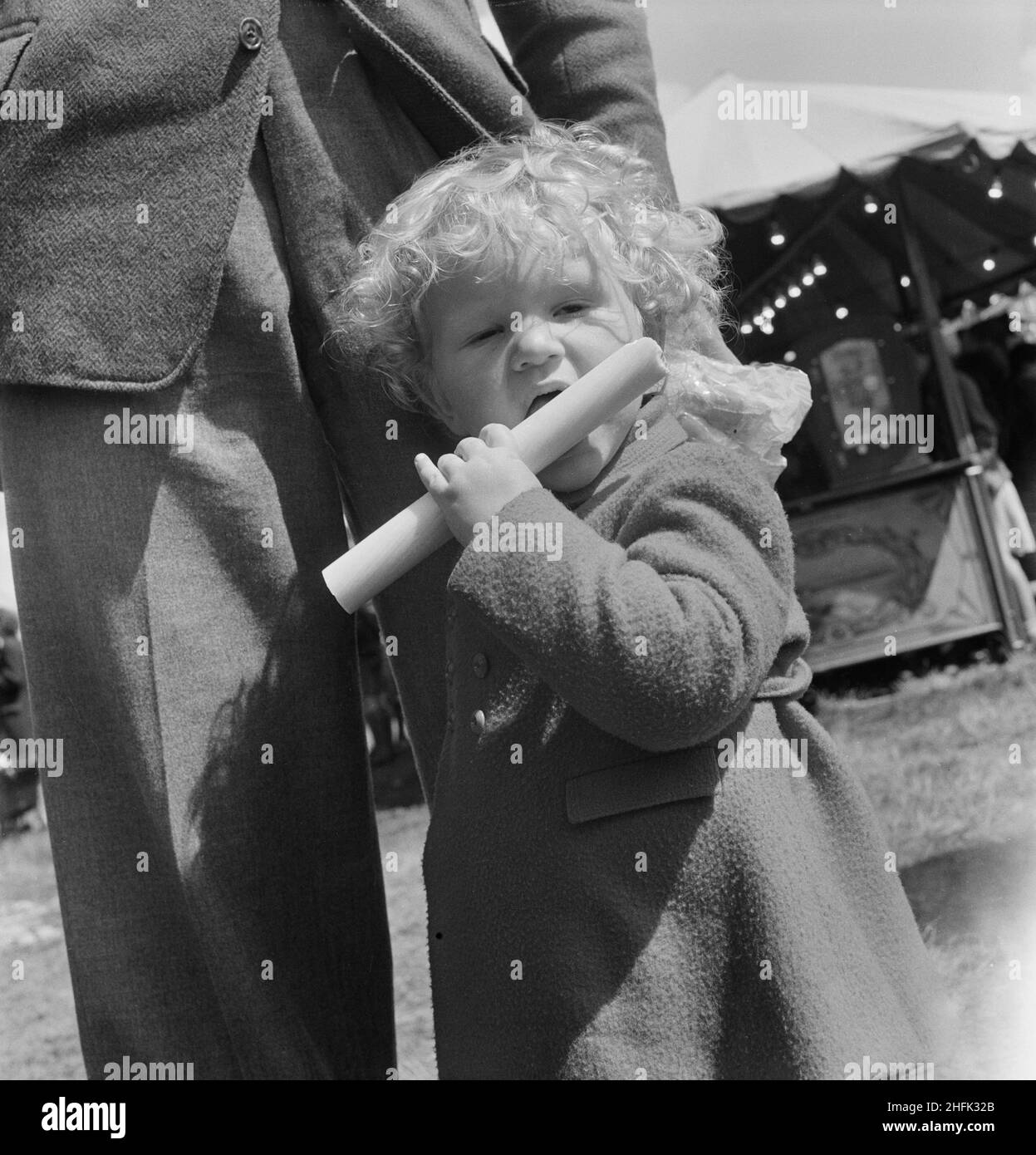 Minehead, West Somerset, Somerset, 28/05/1949. A portrait of a child eating a stick of rock during an outing of Laing staff and families to Minehead. This outing was for Laing staff from the South-West area, including contracts in Bristol, Boscombe Down, Swindon, Cirencester and Gloucestershire. Stock Photo