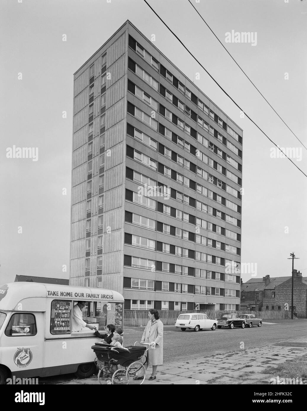 Hornchurch Court, Bonsall Street, Hulme, Manchester, 12/08/1965. A recently completed multi-storey block of 'Sectra' flats in Hulme, probably Hornchurch Court, with a family in the foreground buying from an ice cream van. 'Sectra&#x2019; was a French prefabricated steel formwork design for flats which John Laing and Son Ltd acquired the British rights to in 1962. It was a method of using precision made steel formwork for the placing of structural concrete in 'tunnel' sections in room unit widths and ceiling heights. The units were bolted together in rows on special tracks, with the concrete po Stock Photo