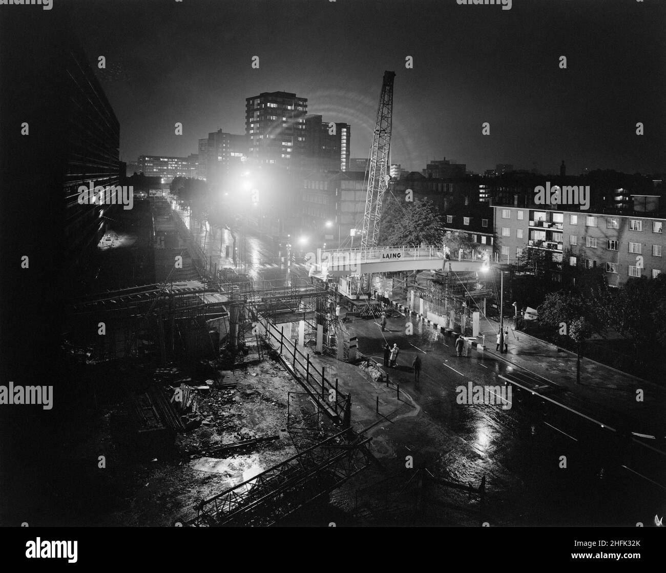 New Kent Road, Newington, Southwark, London, 12/06/1973. A 60-tonne Gargantua crane lowering the central section of deck into place during the construction of a footbridge over New Kent Road, Southwark. The police closed the road from 8pm on the 12th of June 1973 until 5.30am on the 13th to allow Laing's Southern Region division to build the footbridge. It linked the Heygate Estate of Jespersen flats to the north side of the road. The central box section concrete beam was 14m long and weighed 30 tonnes, the largest single unit produced by the John Laing Concrete factory in Andover at the time. Stock Photo