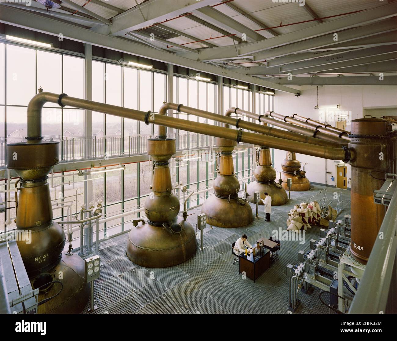 Gordon's Gin distillery, Southfields, Laindon, Basildon, Essex, 09/01/1990. A view from the first floor of the recently completed distillery for Gordon's Gin, looking towards its five copper stills and two men working on the floor below. Stock Photo