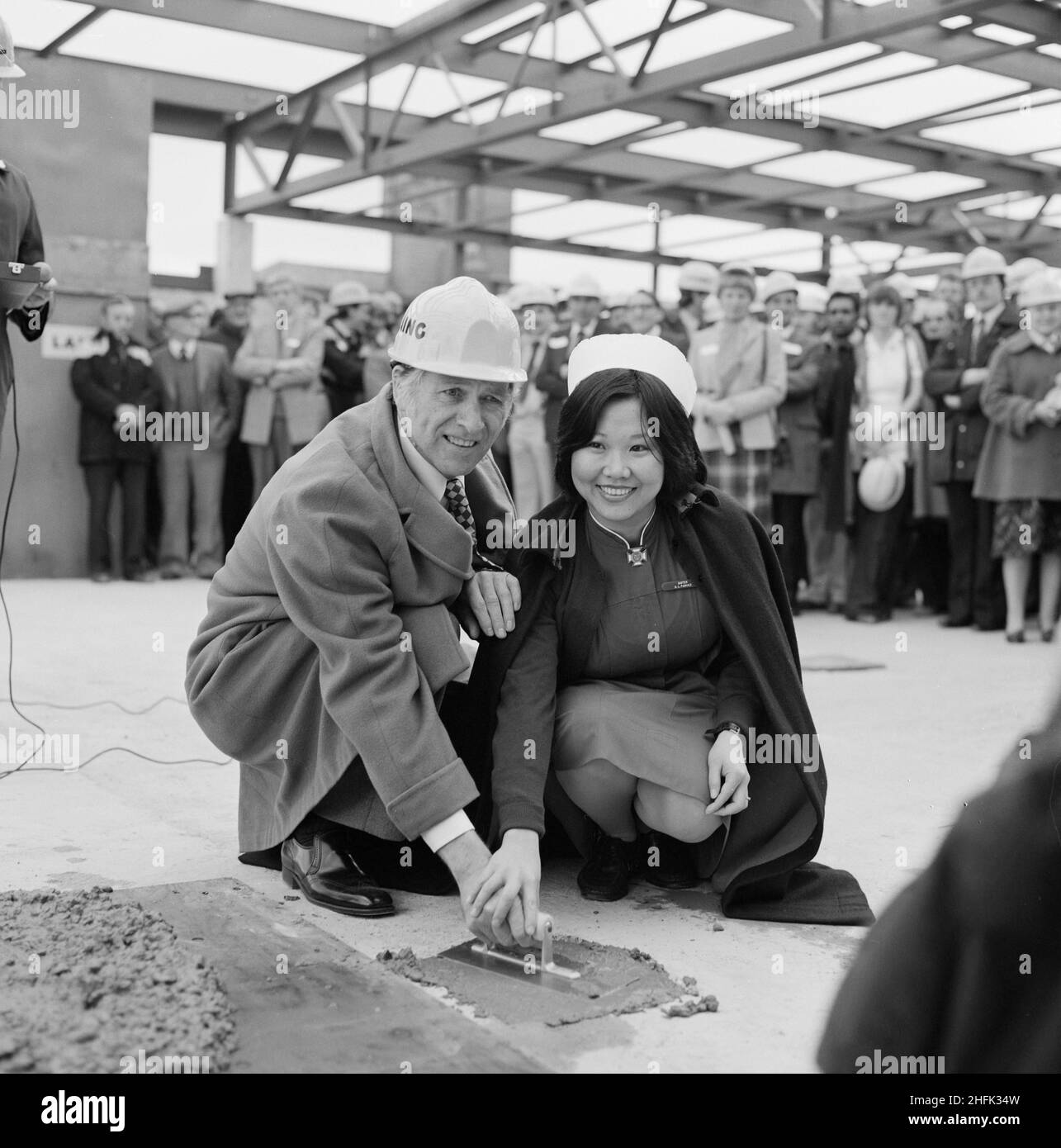 Mayday Hospital, London Road, West Thornton, Croydon, London, 01/05/1981. Denis Sweaney, Chairman of Croydon Area Health Authority, and Sister S Parvez smoothing the final batch of concrete during the topping out of the services block at Mayday Hospital. Laing&#x2019;s Southern Region was awarded the contract for the first phase of a multi-million pound five phase redevelopment project at Mayday Hospital. The contract included a new three storey surgical block with a linked service block, which was to be connected to the main hospital complex by bridge. The topping out of the services block at Stock Photo