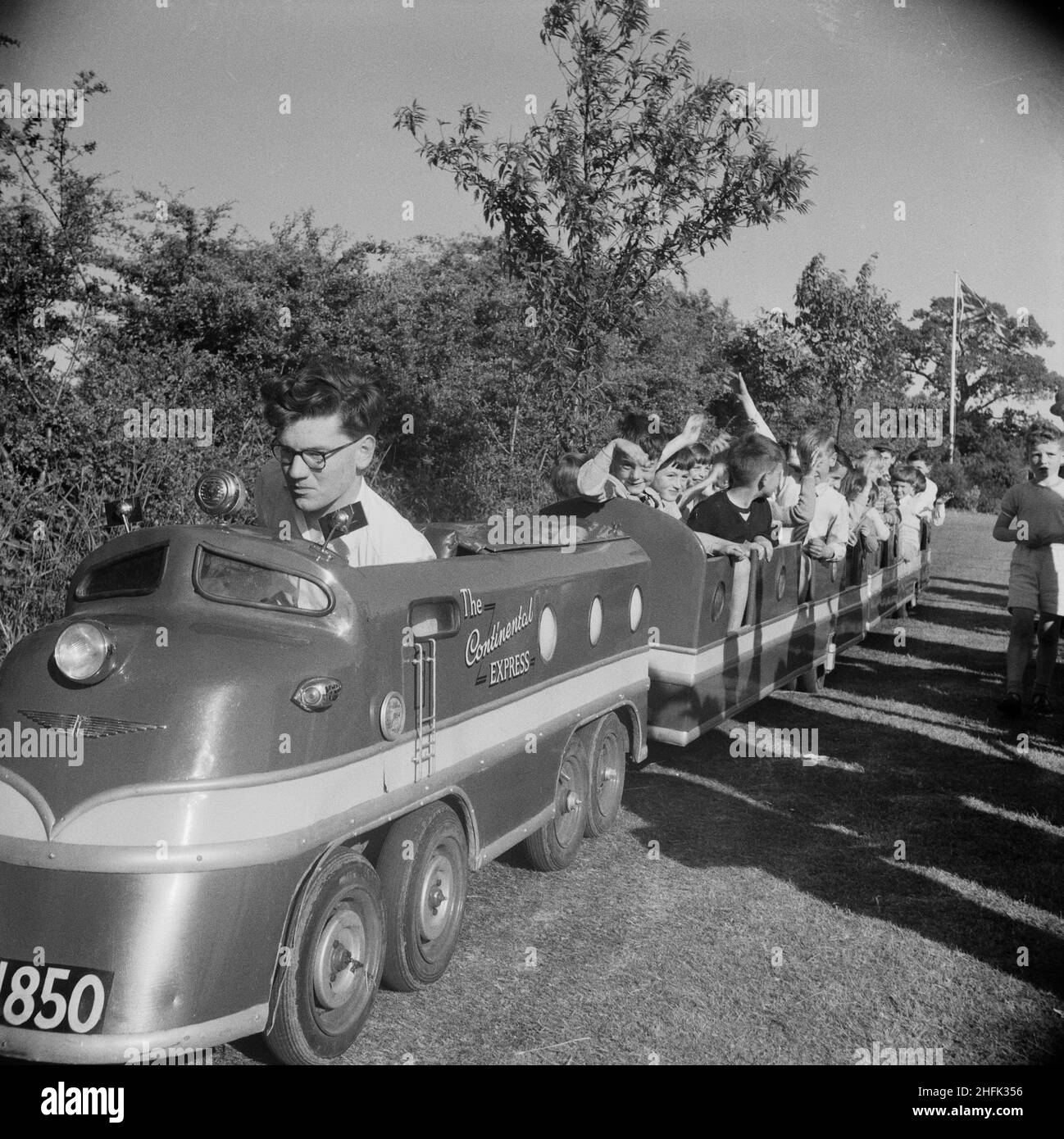 Laing Sports Ground, Rowley Lane, Elstree, Barnet, London, 18/06/1955. Children taking a ride on a miniature train named 'The Continental Express' during a Laing sports day at Elstree. This sports day was attended by people from Laing contracts in Thurleigh, Bradford, Harlow, Shell Haven, London, Welwyn Garden City, Leicester and even as far as Plymouth. The day included field and track competitions as well as special attractions including Scottish dancing, a flower show, gymnastic displays and music by the Silver Band of the 5th Hendon Company Boys' Brigade. Stock Photo