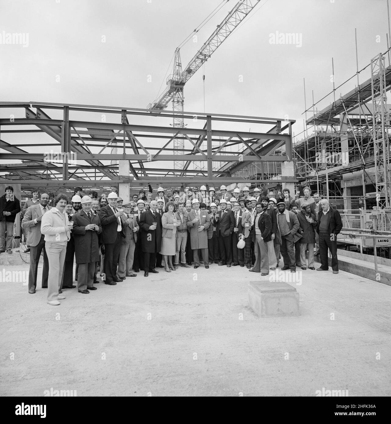 Mayday Hospital, London Road, West Thornton, Croydon, London, 01/05/1981. A group of people posed with celebratory drinks on the roof of the services block at Mayday Hospital during the topping out ceremony. Laing&#x2019;s Southern Region was awarded the contract for the first phase of a multi-million pound five phase redevelopment project at Mayday Hospital. The contract included a new three storey surgical block with a linked service block, which was to be connected to the main hospital complex by bridge. The topping out of the services block at Mayday Hospital was aptly held on May Day. Dur Stock Photo