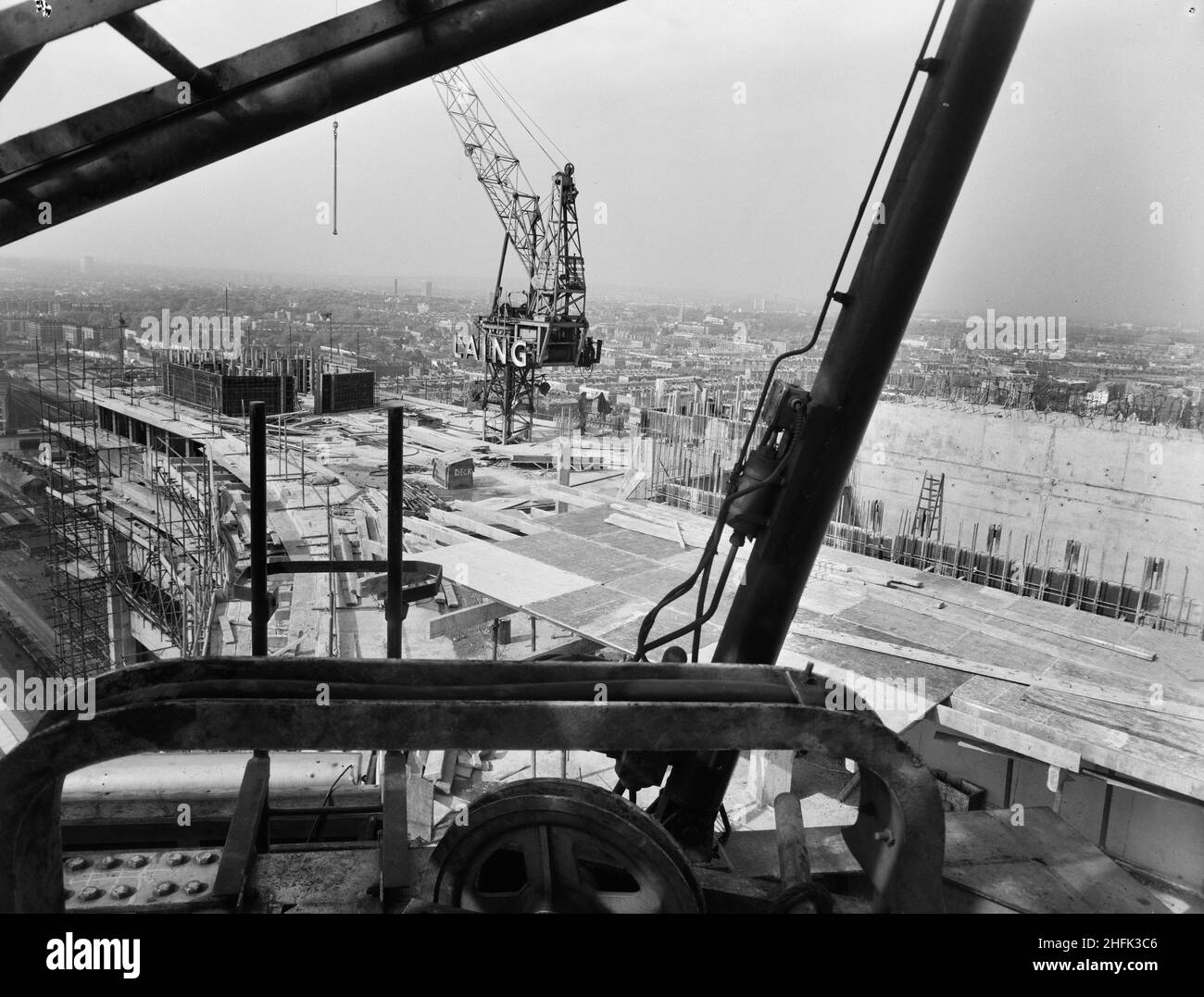 Empress State Building, Lillie Road, Earl's Court, Hammersmith and Fulham, London, 08/05/1961. A view looking north from the controls of one Laing crane towards another on the roof of the Empress State Building during its construction. Laing built the foundations and the reinforced concrete frame of the building, work began in November 1959 and ran until July 1961. Stock Photo