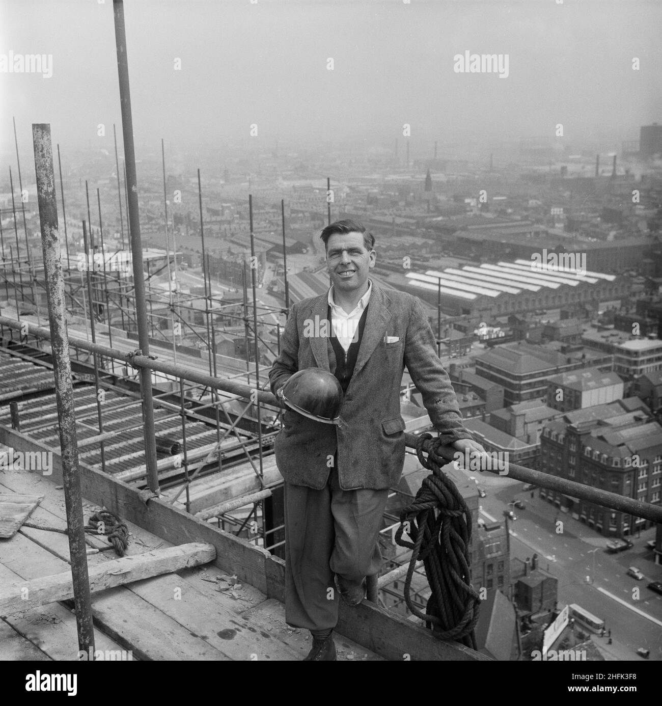 CIS Building, Cooperative Insurance Society Tower, Miller Street, Manchester, 07/06/1961. Bill Whelan, a Weitz G.60 tower crane driver, posed on the construction site of the Co-operative Insurance Society (CIS) Building in front of a view across Manchester. In 1959, the Laing Company began work on the construction of two office blocks for the Co-operative Society in Manchester. The Co-operative Insurance Society (CIS) tower was over 350ft high when completed in 1962, and was the tallest office block in the country at the time. On an adjacent site, a smaller 14-storey high office block for the Stock Photo