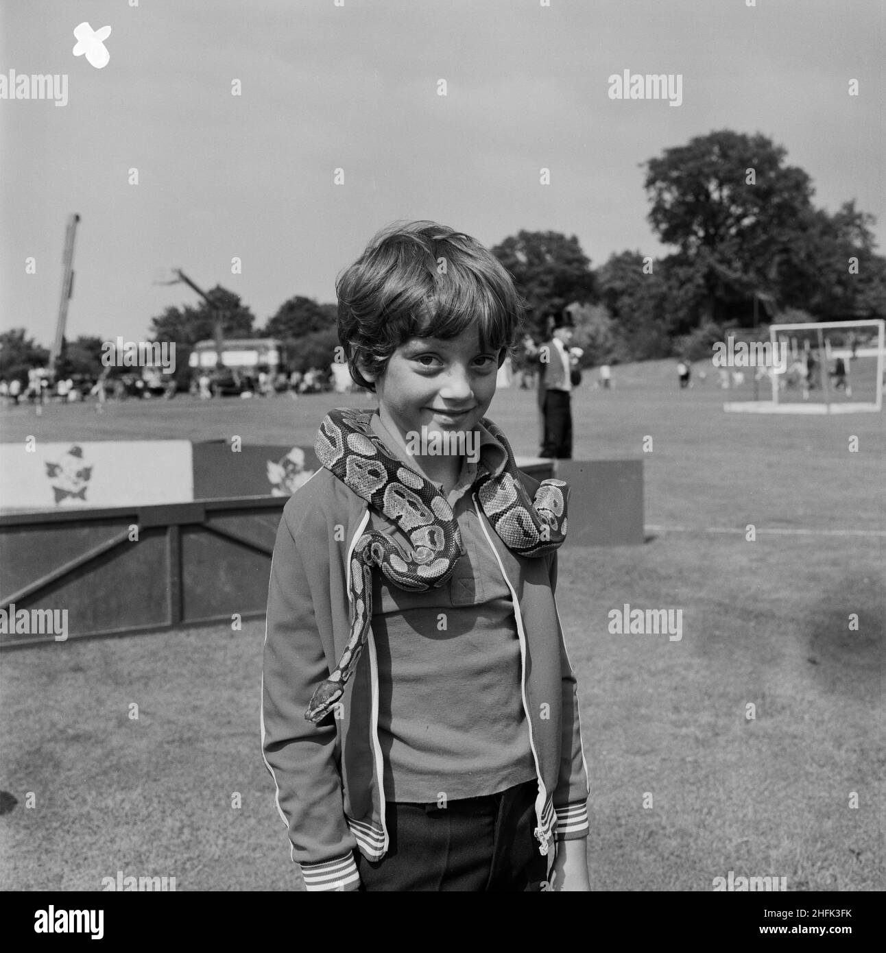 Laing Sports Ground, Rowley Lane, Elstree, Barnet, London, 16/06/1979. A smiling boy with a python wrapped around his shoulders at the annual Laing Gala Day. An article published in August 1979 in Laing's monthly newsletter 'Team Spirit' describes that Gandey's Miniature Circus attended the event with acts including performing dogs, horses, llamas and a snake. Stock Photo