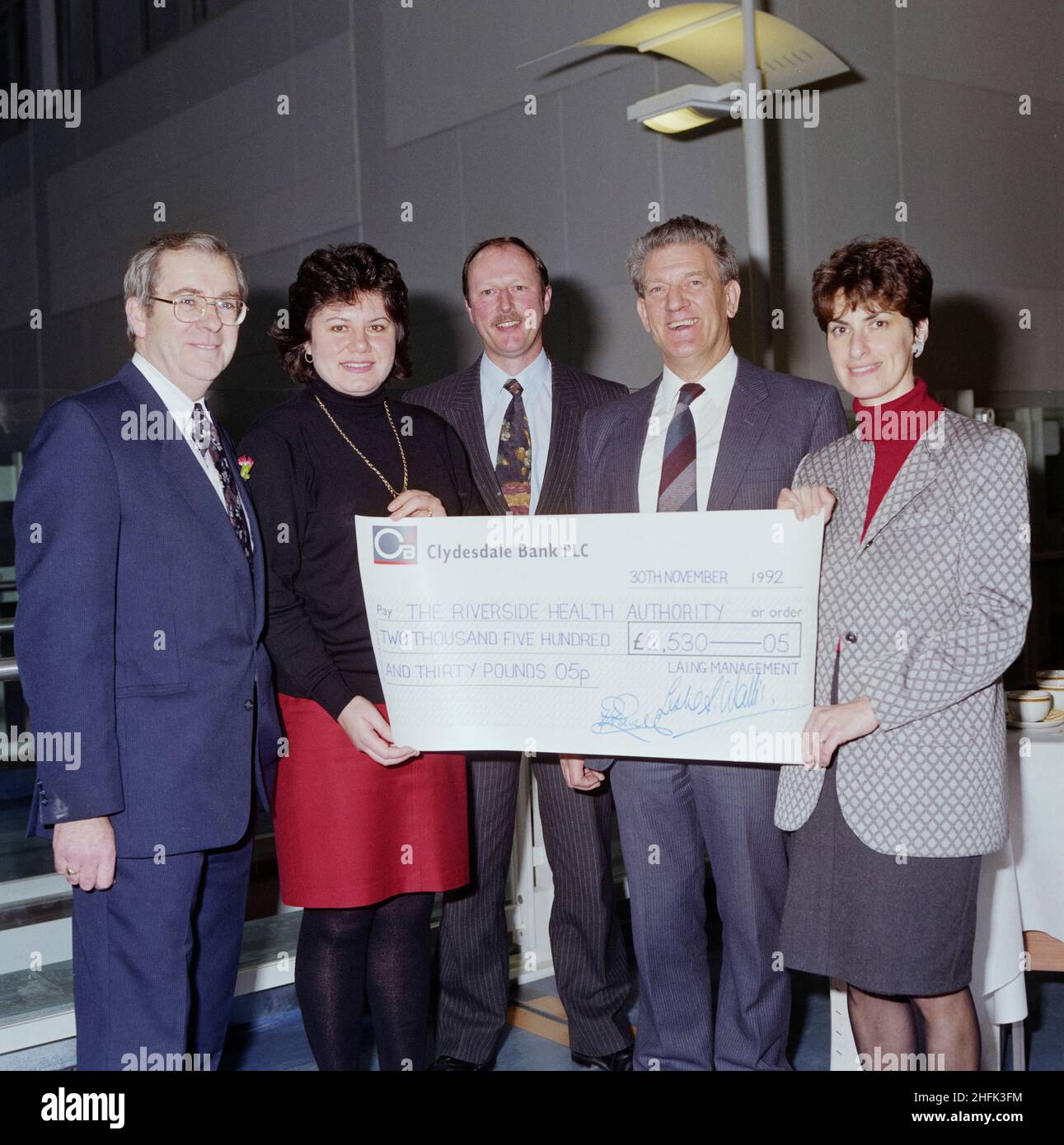 Chelsea and Westminster Hospital, Fulham Road, Kensington and Chelsea, London, 30/11/1992. Representatives of Laing Management and The Riverside Health Authority posed with a large cheque at the handover ceremony for Chelsea and Westminster Hospital. Laing Management held an open day at Chelsea and Westminster Hospital in September 1992, and the proceeds were presented at the hospital's handover ceremony on 30th November. The cheque for &#xa3;2530.05 was presented by Laing staff members Peter Powell and Roger Hopkins to representatives of the Riverside Health Authority. The money was to be use Stock Photo
