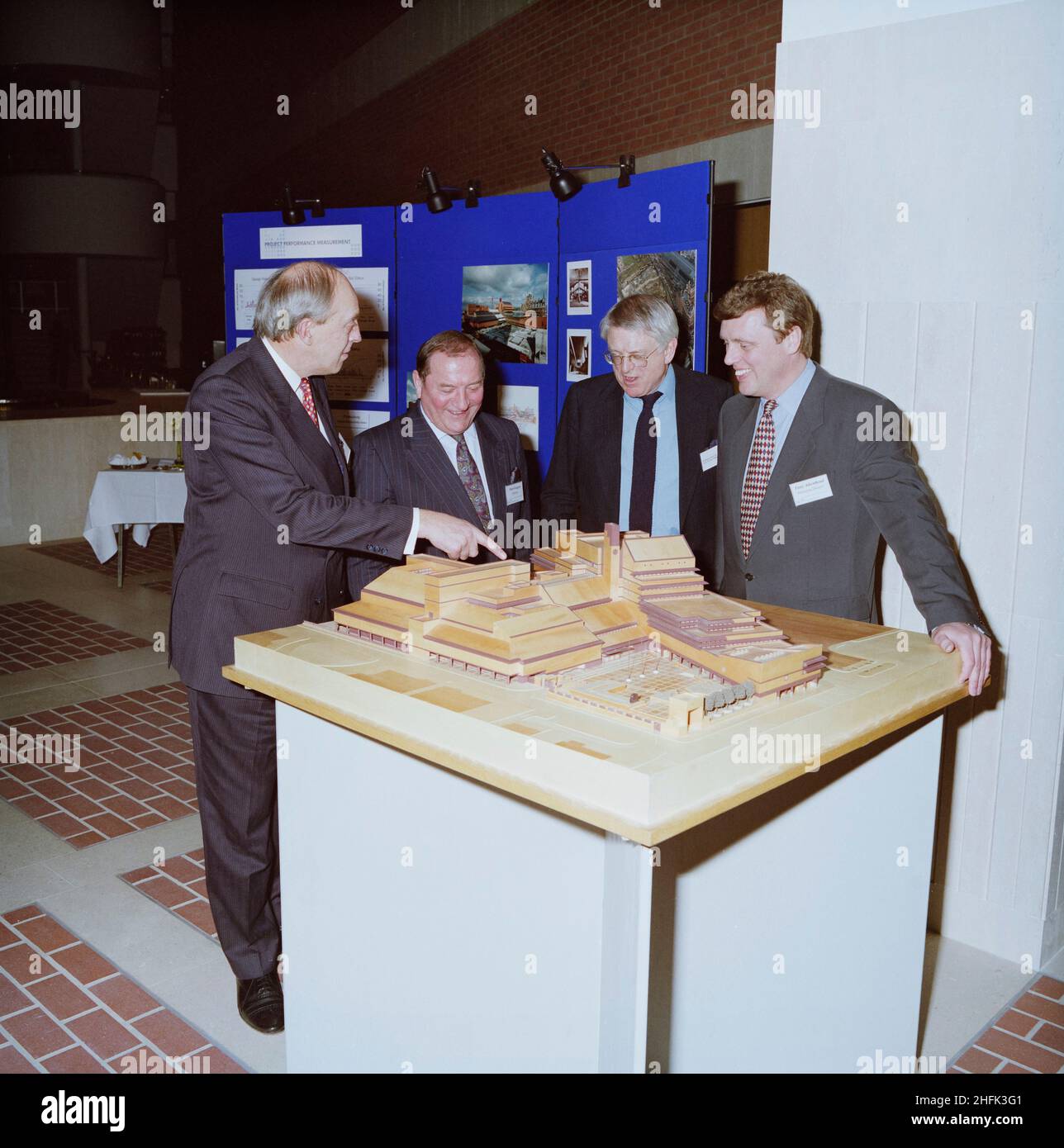 British Library, Euston Road, St Pancras, Camden, London, 06/03/1996. The British Library's architect, Colin St John Wilson and Laing dignitaries admire a scale model of the building at a reception to celebrate its completion. Those pictured are Martin Laing, Laing Group Chairman, Peter Gregory, Chairman of Laing Management and Tony Atkinhead, Managing Director of Laing Management. The British Library as an entity was established in 1973 by an act of parliament bringing together various disparate elements including the collections of the British Museum Library, the National Sound Archive and t Stock Photo