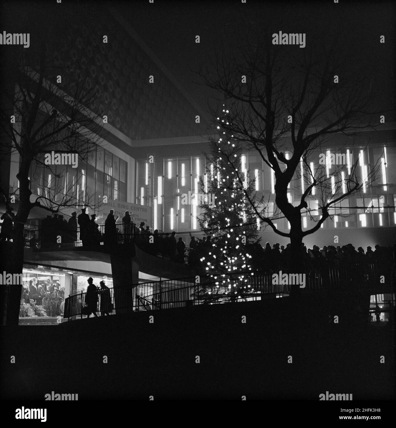 Bull Ring Centre, Birmingham, 23/12/1963. A silhouetted view of a carol service being held on the spiral ramp at the Bull Ring Centre. Stock Photo