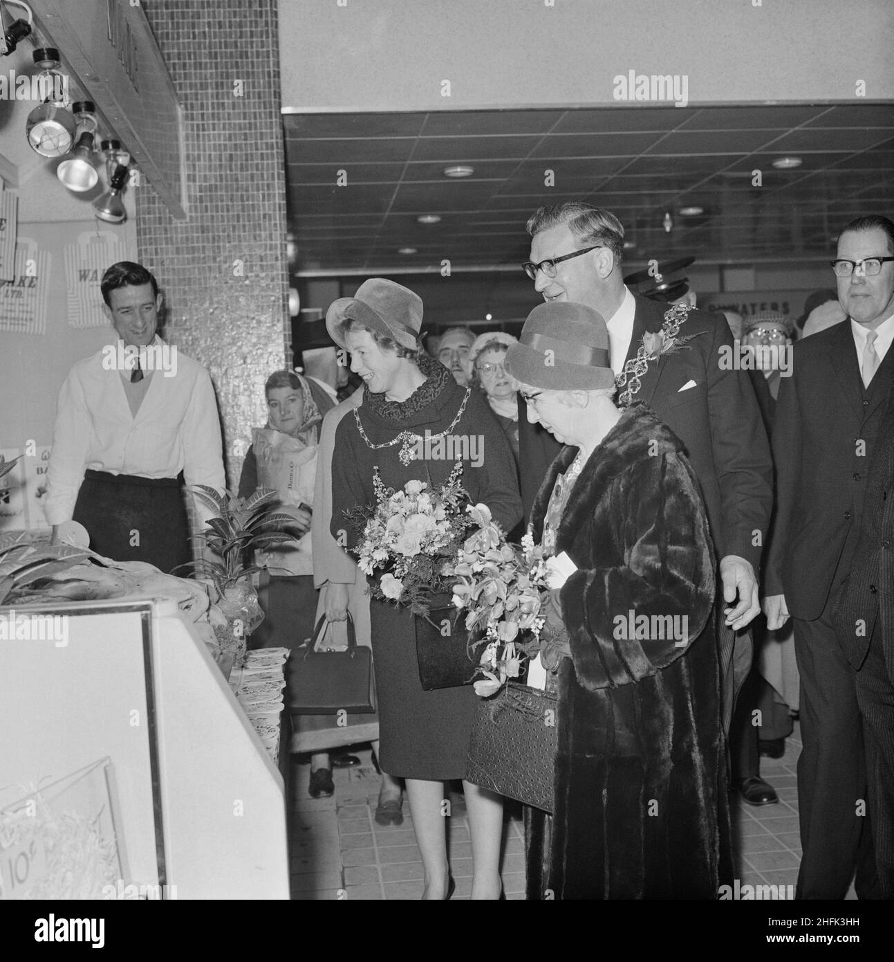 Bull Ring Centre, Birmingham, 14/11/1963. Dignitaries touring stalls during the official opening of the retail market at the Bull Ring Centre. On 14th November 1963, the retail market at the Bull Ring development was opened by the Lord Mayor of Birmingham, Alderman Dr. Louis Glass, JP. The new retail market replaced the old Market Hall building, which was originally built in 1835 but had suffered serious damage from an air strike in the Second World War. The general section of the new market housed 154 stalls, with a further 42 in the separate fish and poultry section. The dignitaries shown in Stock Photo