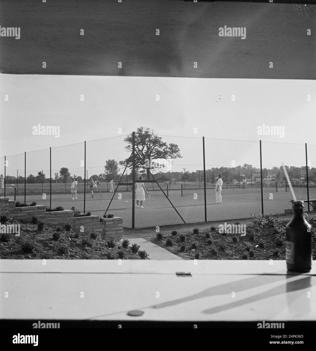Laing's new Sports Ground in Elstree, Hertfordshire, 13/08/1949. A view through a hatch towards people playing tennis at Laing's new Sports Ground in Elstree. Stock Photo