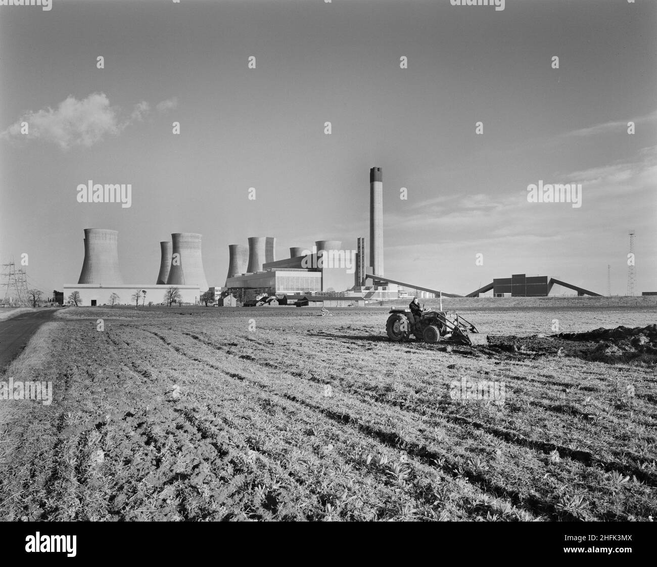 A view of Eggborough Power Station from the south-west, showing a front-loader tractor working in the field in the foreground. This image was catalogued as part of the Breaking New Ground Project in partnership with the John Laing Charitable Trust in 2019-20. Stock Photo