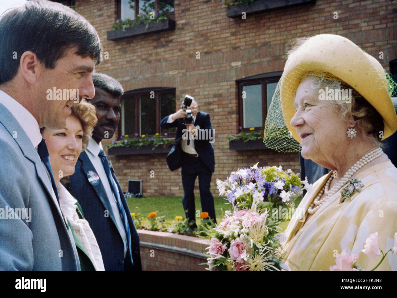 Four Limes, Wheathampstead, St. Albans, Hertfordshire, 07/05/1986. The Queen Mother in conversation with Laing Retirement Homes staff at the opening of the Four Limes retirement complex. Laing announced the contract to construct 44 one and two bedroom flats and 6 two bedroom bungalows in June 1985 and the retirement complex was largely complete by the official opening by the Queen Mother in May 1986.  One of the homes in the complex was the 3 millionth to be built under the auspices of the National House Building Council's 10 year warranty scheme, in its 50th year.  A large 17th century house Stock Photo