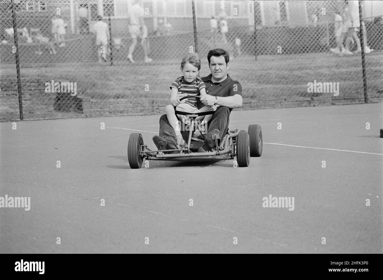 Laing Sports Ground, Rowley Lane, Elstree, Barnet, London, 14/06/1969. A man and boy driving a go-kart on a tennis court during a Gala Day held at the Laing Sports Ground at Elstree. A Gala Day was held by Laing at the Laing Sports Ground on 14th June 1969, as a replacement of the annual Sports Day. Sports events were held by the Sports Club, which included hockey, tennis, bowls, and football tournaments. A traditional English fete programme featured coconut shies, bingo, pony rides, catering and a beer tent, candy floss, and roundabouts. The day ended with a beauty contest, prize draw, and th Stock Photo