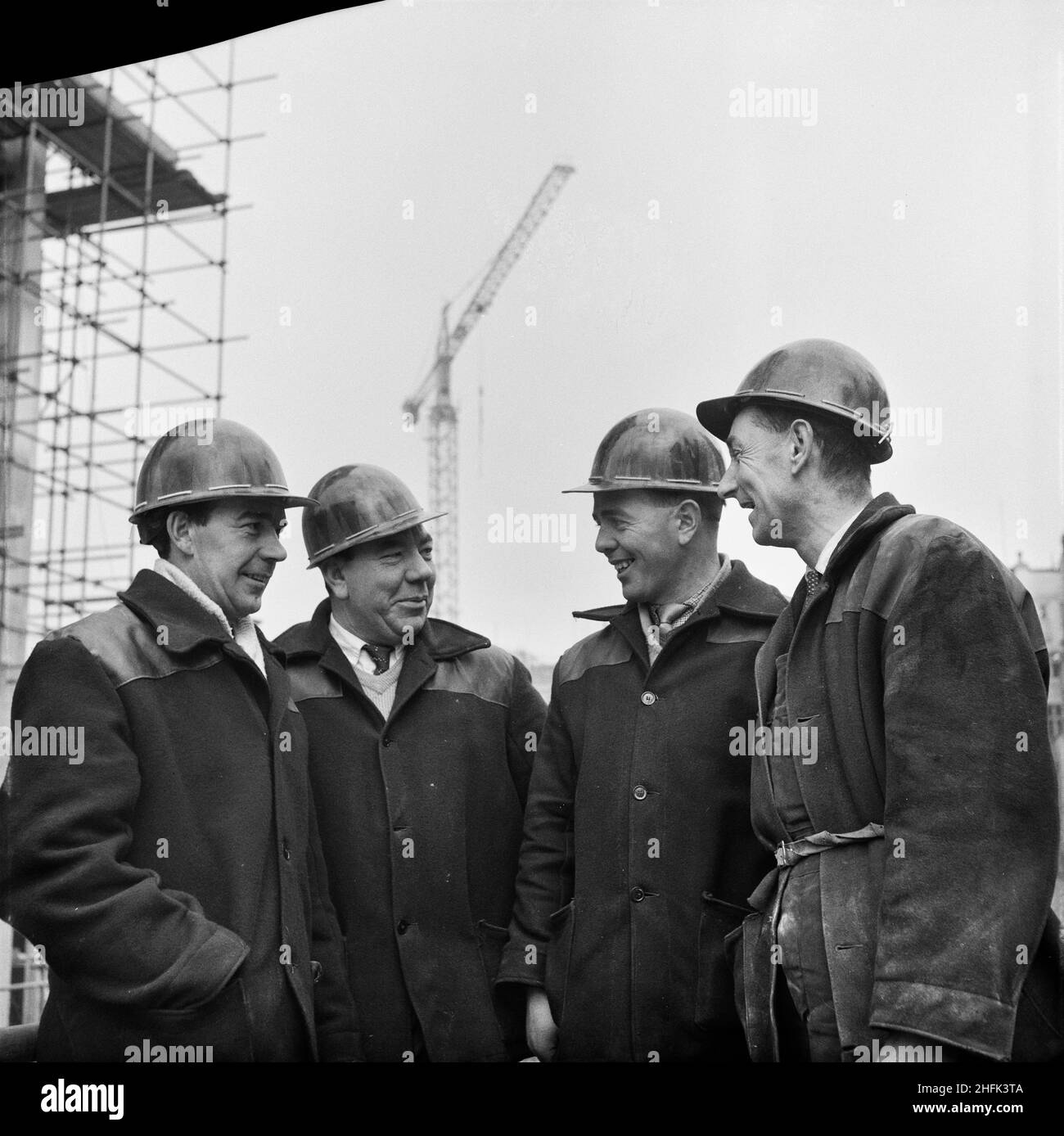 Paternoster Square, City of London, 15/01/1963. Four workmen employed on the construction of the Paternoster development. Photographs of these four workers were published in the February 1963 issue of Laing's monthly newsletter, Team Spirit. From left to right: G Otley, concreting ganger; J White, foreman joiner; P Enright, walking ganger; R Coxhead, carpenter/joiner.Work on the Paternoster development was carried out in a joint venture by John Laing Construction Limited, Trollope and Colls Limited, and George Wimpey and Company Limited. The scheme involved the redevelopment of a seven acre si Stock Photo