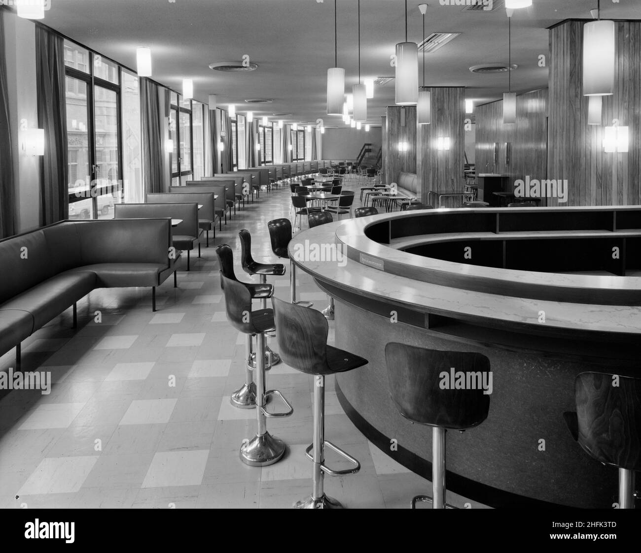 Paternoster Square, City of London, 23/06/1965. A view of tables and seating in an empty restaurant at the Paternoster development. Work on the Paternoster development was carried out in a joint venture by John Laing Construction Limited, Trollope and Colls Limited, and George Wimpey and Company Limited. The scheme involved the redevelopment of a seven acre site on the north side of St Paul&#x2019;s Cathedral. The site had been almost entirely devastated during an incendiary raid in December 1940. The development consisted of a series of office blocks, a shopping precinct, an extensive piazza Stock Photo