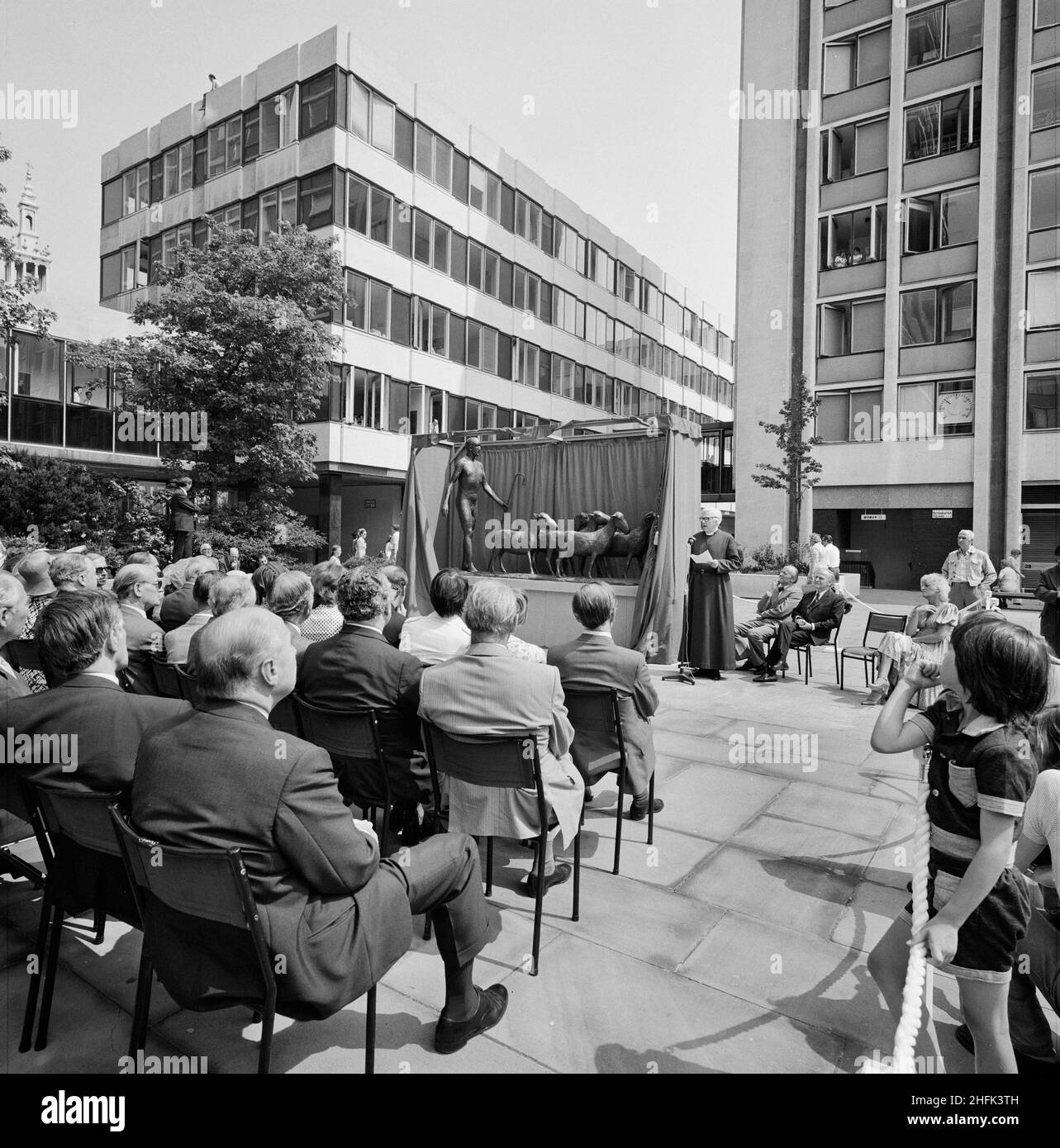 Paternoster Square, City of London, 30/07/1975. Guests listening to a speech during the unveiling ceremony for the bronze sculpture of a shepherd and sheep by Elisabeth Frink at the Paternoster development. Work on the Paternoster development in the 1960's was carried out in a joint venture by John Laing Construction Limited, Trollope and Colls Limited, and George Wimpey and Company Limited. The development consisted of a series of office blocks, a shopping precinct, an extensive piazza and a three-level car park.In July 1975, a bronze statue of a shepherd and his sheep, sculpted by Elisabeth Stock Photo